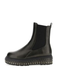 Stivale alla caviglia in pelle nera con pannelli laterali elasticizzati, suola spessa decorata con borchie metalliche e linguetta sul retro.