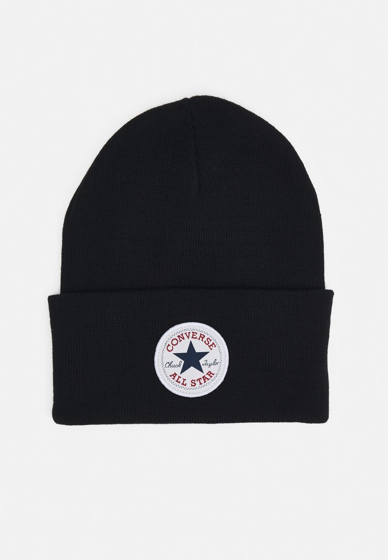 Gorro de punto negro con puño enrollado que presenta un parche redondo blanco con un logo de estrella y el texto "Converse Chuck Taylor All Star."