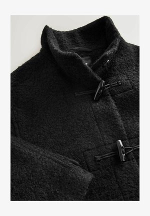 Černý vlněný kabát s vysokým límcem, strukturovanou tkaninou a zapínáním na klopy, s čistým, minimalistickým designem a jemnými švy.