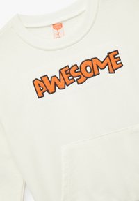 Sudadera blanca con el texto bordado "AWESOME" en naranja, con cuello redondo y detalle de bolsillo frontal. Tejido suave y texturizado.
