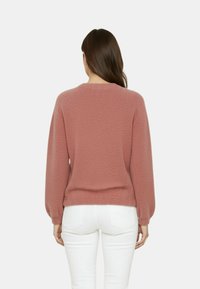 Maglione a maglia color rosa polvere con maniche a palloncino e scollo rotondo, caratterizzato da un motivo testurizzato e un orlo inferiore aderente.