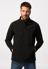 Sort softshell-jakke med højt krave, lynlås-lukning og lynlås-lomme på brystet. Har lange ærmer og en glat, tekstureret overflade.