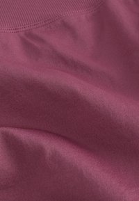 Teksturowana tkanina w głębokim odcieniu mauve, charakteryzująca się subtelnym połyskiem, miękkim układem i delikatnym prążkowanym wzorem. Gładka powierzchnia z łagodnymi fałdami.