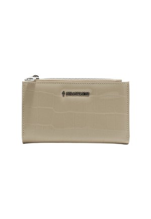 Portefeuille en simili cuir beige avec un motif en crocodile, fermeture éclair et accent logo argenté. Texture lisse avec une forme rectangulaire.