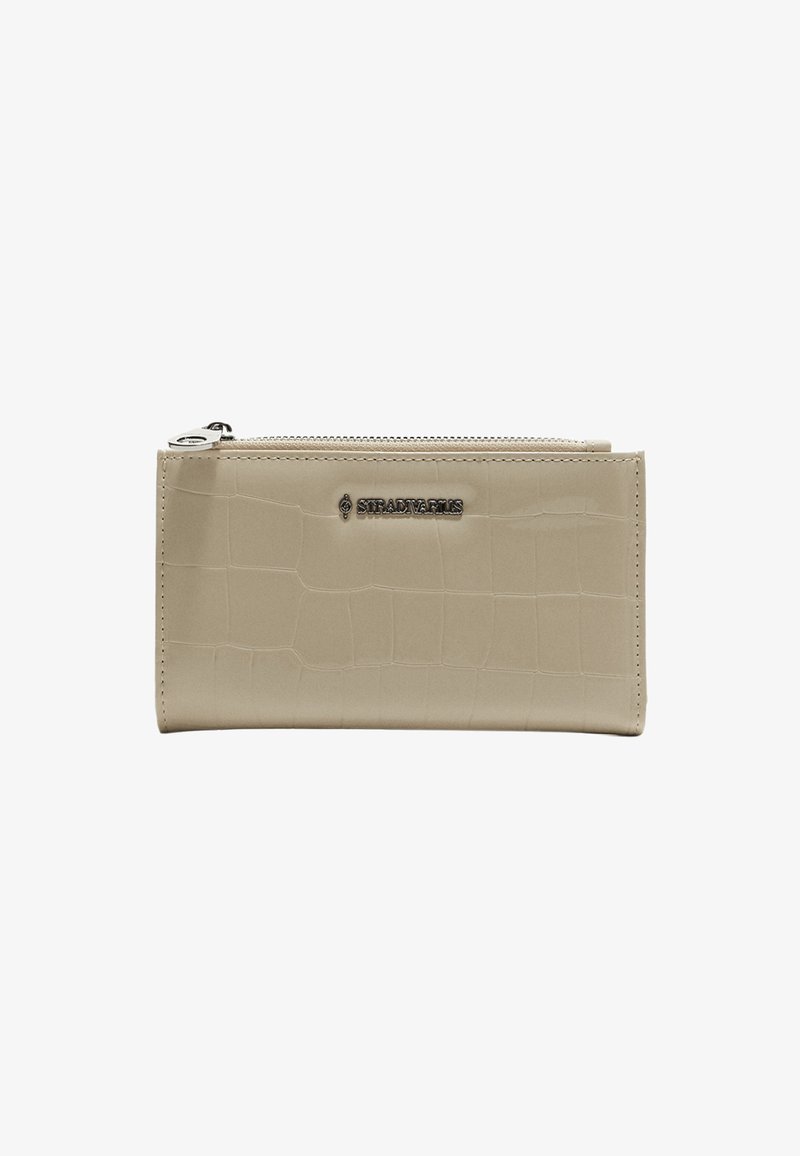 Portafoglio beige in finta pelle con motivo coccodrillo, chiusura a zip e un accento logo argentato. Texture liscia con forma rettangolare.
