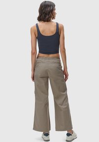 Mörkblå beskuren tanktopp tillsammans med ljusbeige vida byxor. Har elastisk midja, två bakfickor och en avslappnad passform.