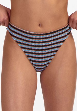 Primo piano di una persona che indossa slip bikini testurizzati con strisce orizzontali nere, blu e rosa, mentre aggiusta la fascia in vita.