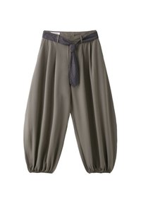 Pantalon ample vert olive avec poignets élastiques, associé à une ceinture en tissu à carreaux foncé nouée en nœud à la taille.