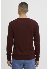 Maroon sweater with a crew neck and ribbed cuffs, made of soft knit material. The back features a smooth texture without patterns.