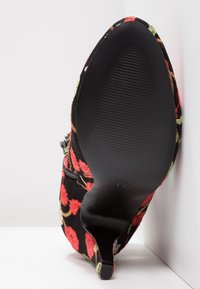 Schwarzer Absatzschuh mit gestickten floralen Mustern in Rot, Orange und Grün, mit einer strukturierten Gummisohle und einer spitzen Zehenform.