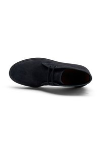 Botín de ante negro hasta el tobillo con punta redondeada, diseño de cordones y un acabado ligeramente texturizado. Suela de goma para agarre y flexibilidad.