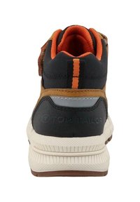 Dziecięcy czarno-brązowy sneaker z pomarańczowym wykończeniem, odblaskowym paskiem i grubą białą podeszwą widziany z tyłu.