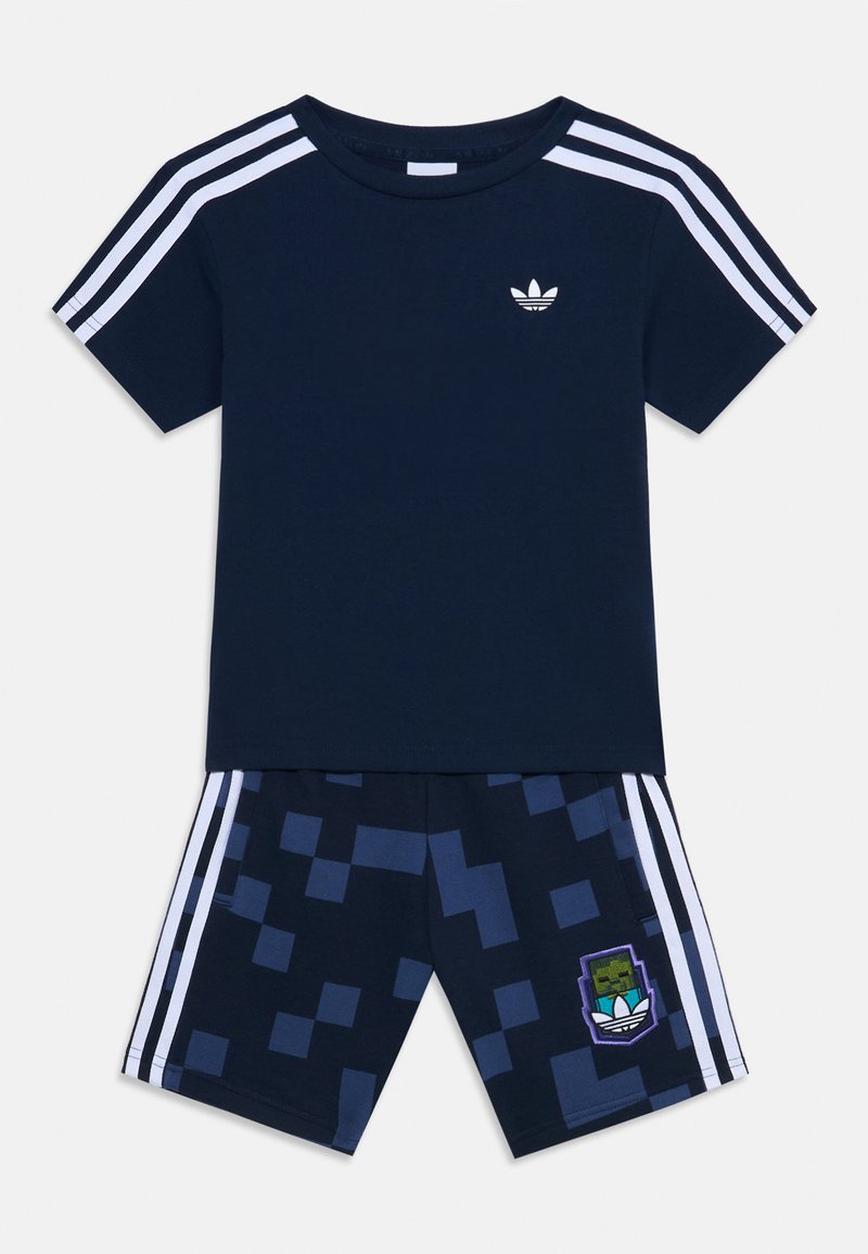 Conjunto de roupa desportiva azul-marinho com uma t-shirt de manga curta com riscas brancas e calções a condizer com padrão pixelado e um logótipo bordado.