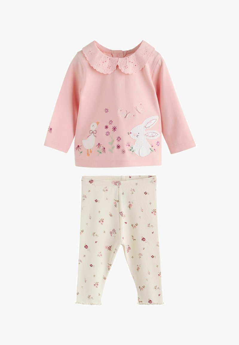 Haut bébé rose à manches longues avec col festonné et imprimés animaux, associé à des leggings crème décorés de petits motifs floraux.