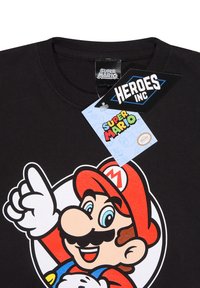 Černé bavlněné tričko s barevným grafikou postavy s knírem, červenou čepicí a modrým tričkem, s štítky "Super Mario" a "Heroes Inc."