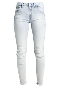 Jeans ajustados de un azul claro, elaborados en denim, con una cintura alta, detalles de rodillas rasgadas y un dobladillo deshilachado.