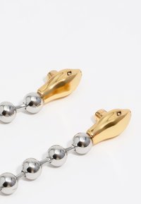 Collar de metal dorado y plateado con una cadena de cuentas esféricas alternas y cierres en forma de pez estilizados. Superficies lisas y reflectantes.
