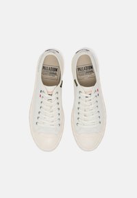 Białe płócienne trampki z okrągłym noskiem, z teksturowaną cholewką, sznurowadłami i gumową podeszwą. Wewnętrzna marka widoczna na języku.