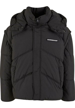 Black puffer jacket with a high collar, zip closure, and side pockets. Features diagonal stitching and a logo patch on the chest.