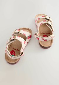 Rosa Sandalen mit Erdbeer-Muster, verstellbaren Metall-Schnallen und einer strukturierten Korksohle. Das Innere weist ein rotes Logo-Detail auf.