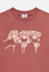 Rosa sweatshirt med tre illustrerade älvor med blomsterkronor, detaljerade vingar och olika rosa och gröna inslag.