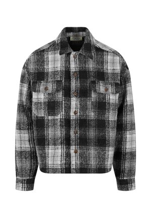 Čierno-biely kockovaný flanelový košeľa s golierom, dvoma prednými vreckami a hnedými gombíkmi. Mäkka textúra a uvoľnený strih.