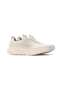 Zapatillas ligeras de slip-on con una parte superior de malla texturizada y transpirable en color beige claro, que cuentan con una suela gruesa y acolchada y tiradores.