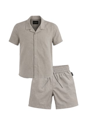 Camicia a maniche corte colore grigio chiaro con colletto e bottoni nascosti, abbinata a pantaloncini con coulisse e vita elastica dello stesso colore.