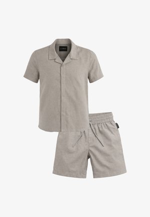 Camicia a maniche corte colore grigio chiaro con colletto e bottoni nascosti, abbinata a pantaloncini con coulisse e vita elastica dello stesso colore.