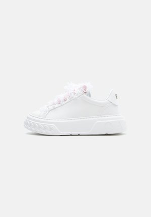 Zapatilla blanca con detalles esponjosos en tonos rosa y blanco a lo largo del lateral, equipada con una gruesa suela de goma y detalles texturizados en la superficie.