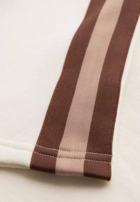 Sweatshirt en tissu crémeux doux, avec un design rayé marron et rose clair le long des manches, des accents en tricot texturé et une couture soignée.