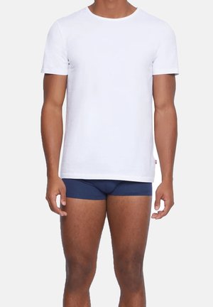 Weißes Baumwoll-T-Shirt mit kurzen Ärmeln und Rundhalsausschnitt, kombiniert mit marineblauen Boxershorts. Einfaches, klassisches Schnittdesign.