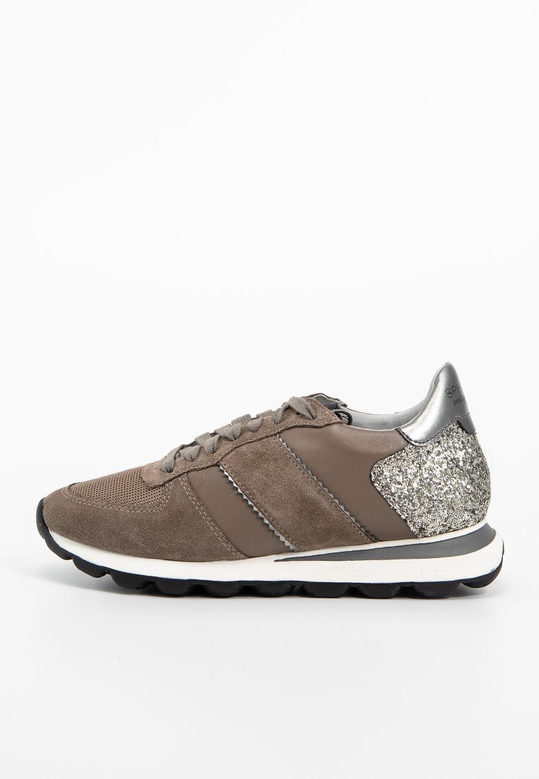 Zapatillas de ante marrón con talón metálico plateado, parte superior de malla y ante, y media suela blanca. Presenta cordones oscuros y sutiles acentos reflectantes.