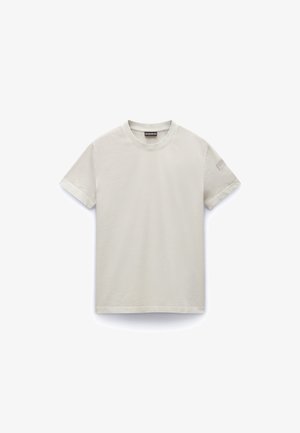 Light beige short-sleeve T-shirt made of cotton. Features a round neckline and a small patch on the left sleeve. Soft texture.