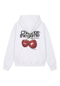 Sweat à capuche blanc avec un motif de deux cerises rouges et le texte « Change the game », « Sweet Life in Monaco » et « Legacy 1980 » au dos.
