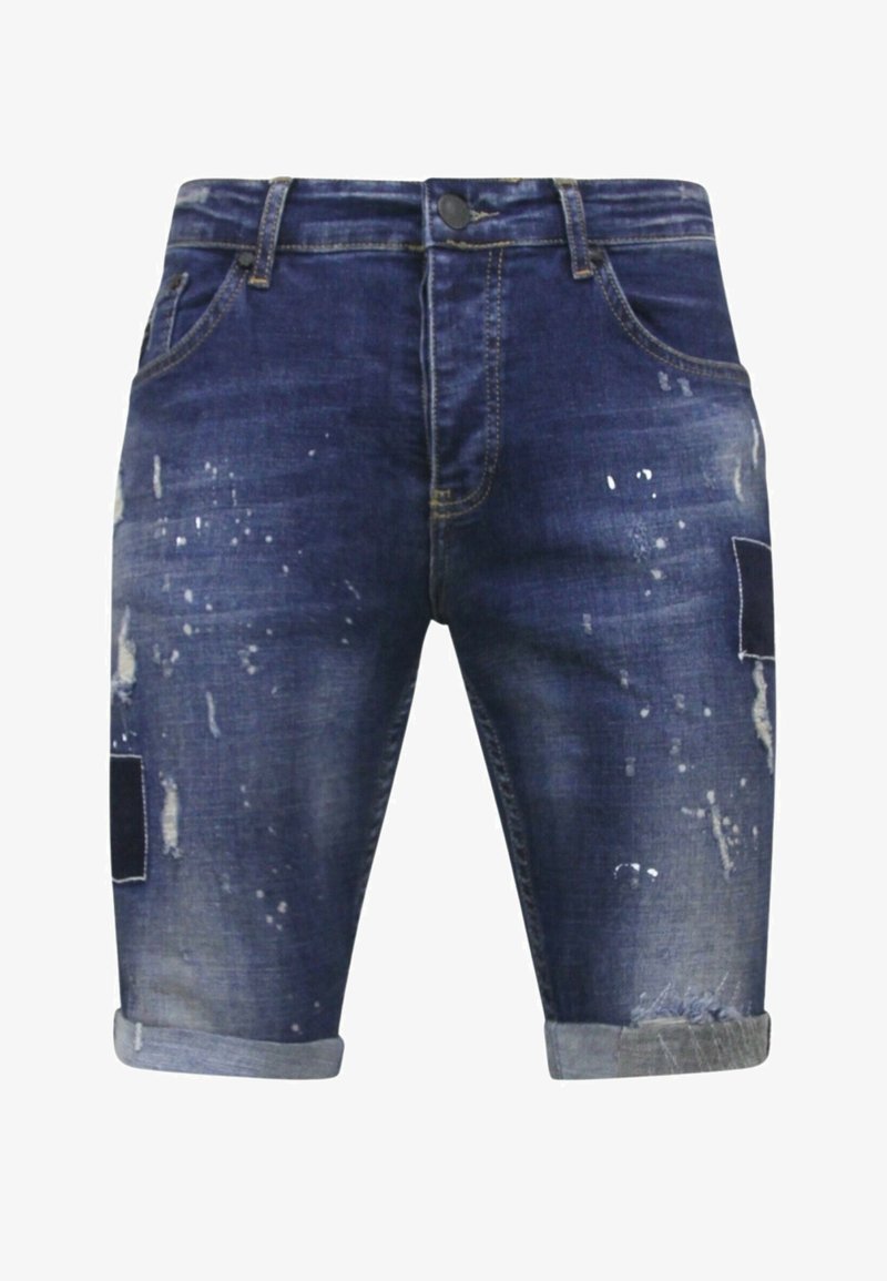 Donkerblauwe denim shorts met een versleten afwerking, voorzien van verfspatten, opgerolde zomen en patchaccenten op beide benen.
