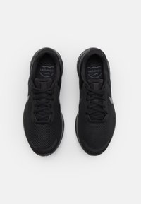 Schwarze Sportschuhe mit einem strukturierten Mesh-Obermaterial, flachen Schnürsenkeln und einer gepolsterten Sohle. Verfügt über ein dezentes Logo und eine geschmeidige Silhouette.