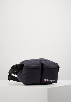 Black Champion waist bag with two front pockets and adjustable strap, displayed on a white surface against a plain background.