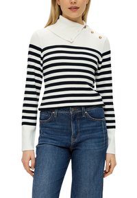 Gestreifter Pullover in Weiß und Marineblau, mit hohem Kragen und drei goldenen Knöpfen am Ausschnitt. Getragen mit blauen Jeans.