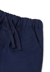 Námořnické modré kraťasy vyrobené z lehkého materiálu, s elastickým pasem na šňůrku, bočními kapsami a malým výšivkou loga.