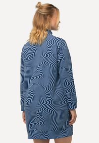 Abito blu a maniche lunghe con un motivo a strisce ondulate di blu scuro. Tessuto morbido con una vestibilità comoda, orlo arrotondato e polsini a coste.