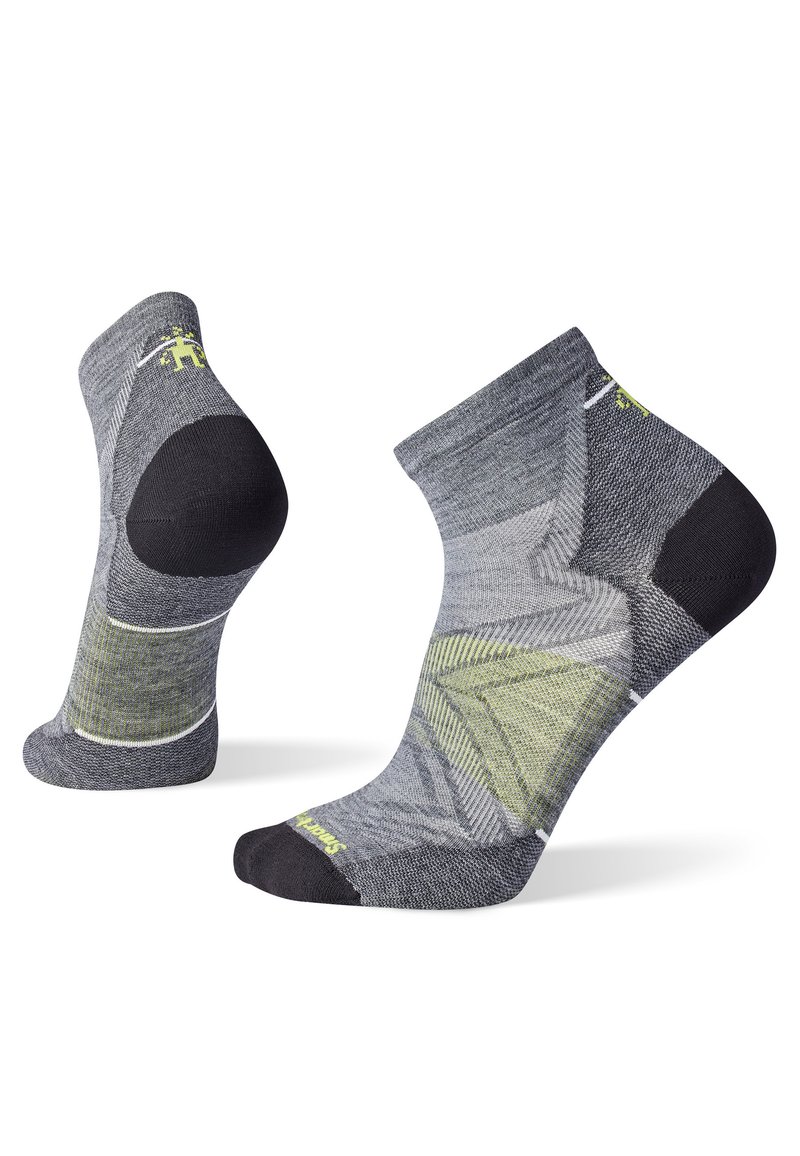 Calcetines de tobillo grises y negros con detalles en verde. Presentan un patrón texturizado y refuerzos en el talón y la punta para mayor durabilidad. Diseñados para la comodidad.