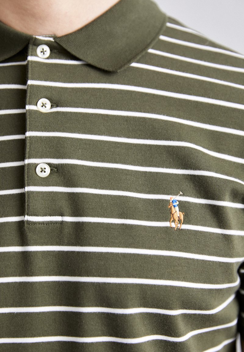 Grün-weiß gestreiftes Poloshirt mit weicher Textur. Verfügt über einen Kragen, drei Knöpfe und ein gesticktes Logo eines Pferdes und Reiters.
