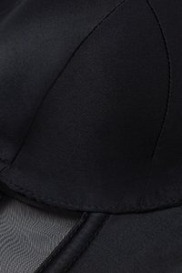 Black fabric bra with a smooth texture and curved cup shape. Features a mesh panel and precise stitching along the edges.