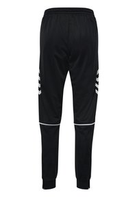 Sorte atletikbukser med hvide chevronstriber på siderne, hvid piping over knæene, elastisk taljebånd og lynlåse ved anklerne.