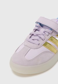 Fioletowe trampki wykonane z połączenia zamszu i tkaniny, z akcentami w postaci złotych pasków, zapięciem na rzep i gumową podeszwą.