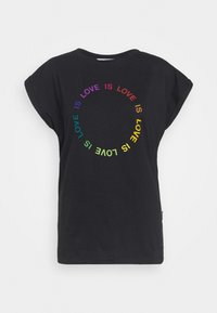 Camiseta de manga corta negra hecha de algodón, con un diseño de texto en arcoíris circular que dice "EL AMOR ES" repetidamente.