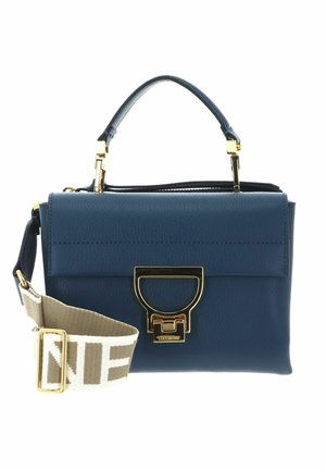 Sac à main en cuir bleu avec poignée supérieure, fermoir doré, et large bandoulière en tissu beige avec grand texte.