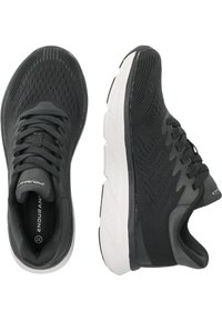 Svarta sportskor med ett ventilerande nätövre, texturerad design och en vadderad vit mellansula. Har snörningsstängning och logotypdetaljer.