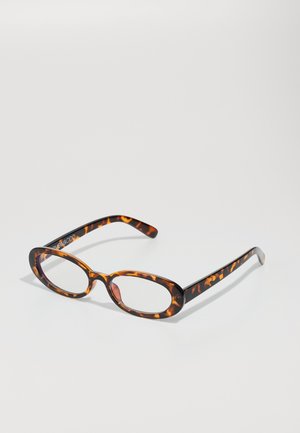 Lunettes en écaille de tortue avec des verres ovales, dotées d'une finition brillante, de branches fines et de motifs subtils ressemblant aux rayures d'un tigre.